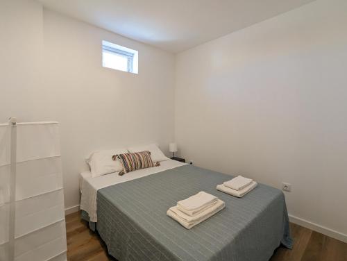 um quarto com uma cama com duas toalhas em Canary's Suite em Matosinhos
