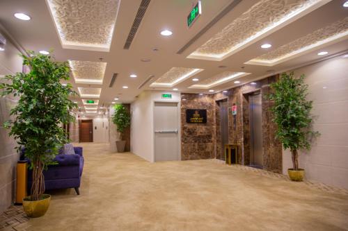 an office lobby with plants and a blue couch at Guest House Hotel Apartments in Yanbu