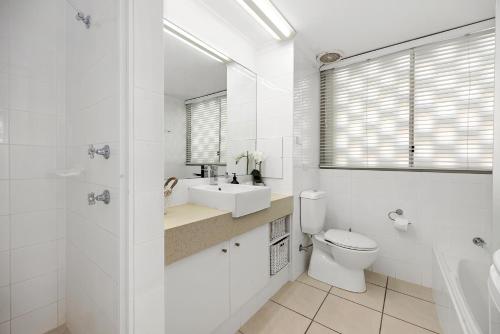 uma casa de banho branca com um WC e um lavatório em Quamby Place, Apt 65 - Garden View em Noosa Heads
