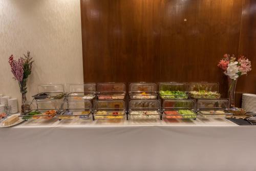 a table with several containers of fish on it at Paradise Inn Jeddah Hotel in Jeddah
