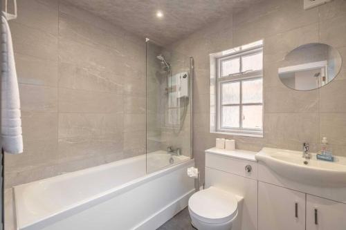 a bathroom with a toilet and a sink and a shower at Cosy Cottage: Your Central Windsor Retreat in Windsor