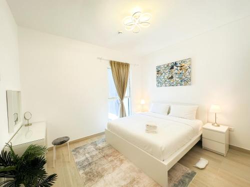 a white bedroom with a white bed and a window at Bord de l'eau 214WB8 in Abu Dhabi