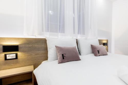 two beds with pillows with the letter t on them at ForS Resort & Spa in Belgrade