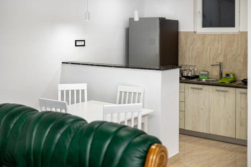 a kitchen with a refrigerator and a table and chairs at ForS Resort & Spa in Belgrade