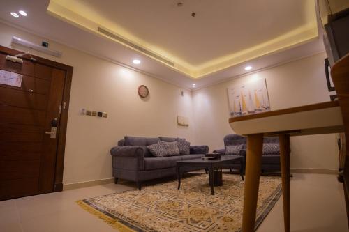 a living room with a couch and a table at Guest House Hotel Apartments in Yanbu