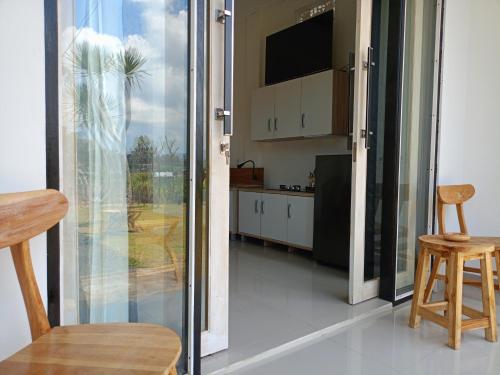 a kitchen with a sliding glass door leading into a room at Batur Homestay and Lodge in Bangli