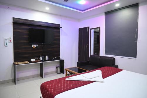 a bedroom with a bed and a flat screen tv at HOTEL DIAMANT INN in Patna
