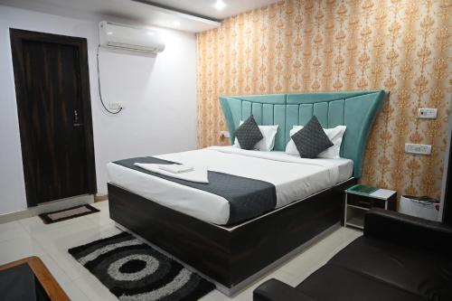 a bedroom with a large bed with a blue headboard at HOTEL DIAMANT INN in Patna