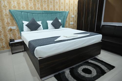 a bedroom with a large bed with a blue headboard at HOTEL DIAMANT INN in Patna