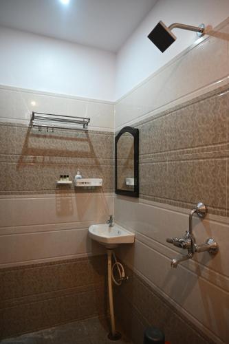 La salle de bains est pourvue d'un lavabo et d'un miroir. dans l'établissement HOTEL DIAMANT INN, à Patna