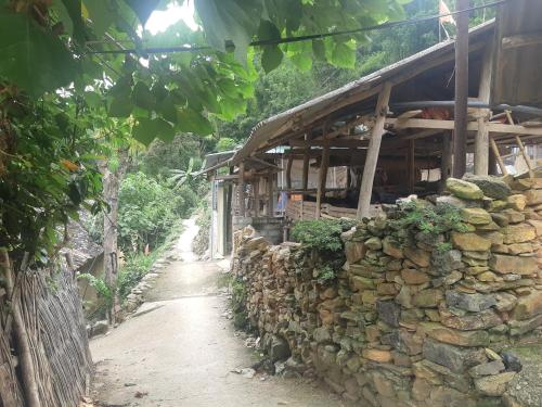 a stone building next to a stone wall at Ha Giang Historic Hotel & Tours in Ha Giang