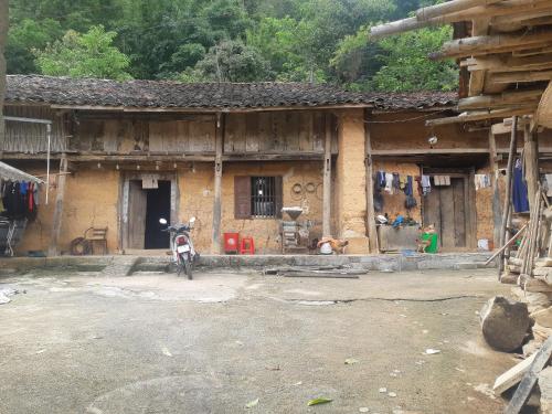 a house with a motorcycle parked in front of it at Ha Giang Historic Hotel & Tours in Ha Giang