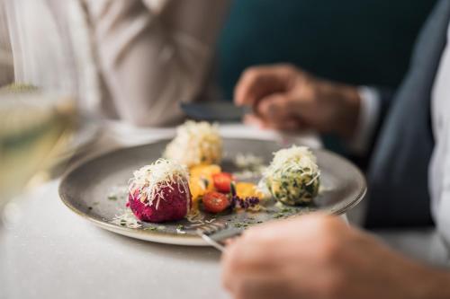 a person holding a plate of food on a table at Biohotel Leutascherhof in Leutasch