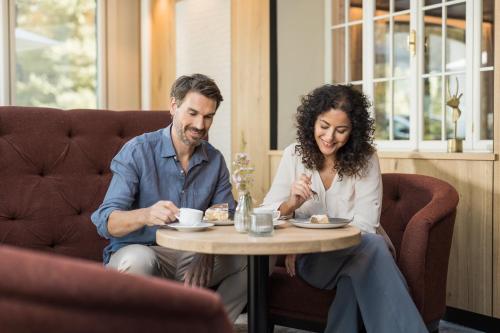 a man and a woman sitting at a table at Biohotel Leutascherhof in Leutasch