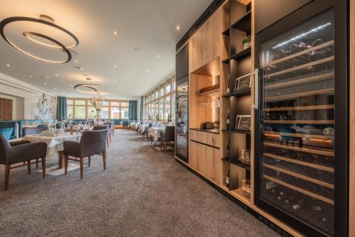 a restaurant with tables and chairs and a wine cellar at Biohotel Leutascherhof in Leutasch