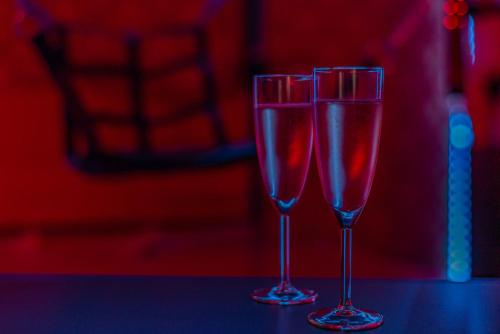 two glasses of wine sitting on a table at Playroom XXL Loft LOVE Room avec Espace spa Terrasse vue sur les toits Salle de jeux pour adultes Libourne centre 10 min de St Emilion Proche Bordeaux in Libourne