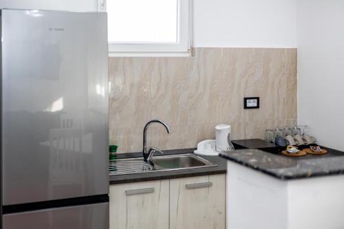 a kitchen with a sink and a refrigerator at ForS Resort & Spa in Belgrade