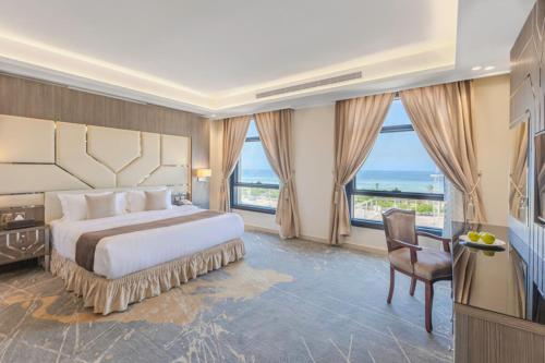 a bedroom with a large bed with a large window at Guest House Hotel Apartments in Yanbu