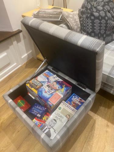 a drawer full of games and books on a couch at Hay On Wye Welsh Townhouse in Hay centre in Hay-on-Wye