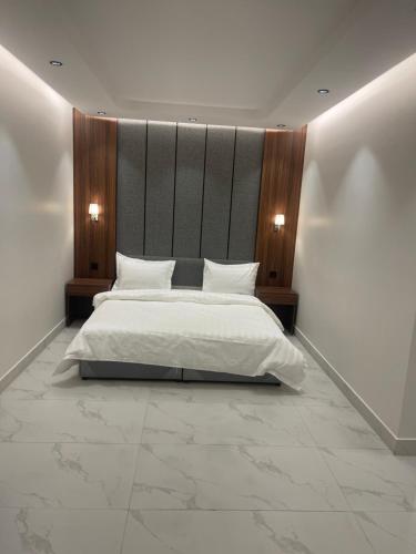 ein Schlafzimmer mit einem großen Bett mit weißer Bettwäsche in der Unterkunft شقق درر رامه للشقق المخدومة 10 in Riad