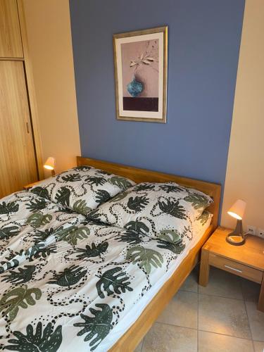 1 dormitorio con 1 cama con edredón verde y blanco en Apartment mit Pool zum Verlieben, en Bad Essen