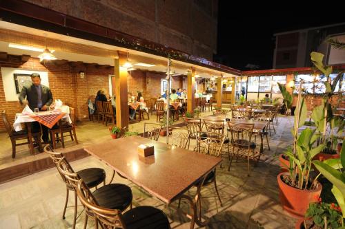a restaurant with tables and chairs and people sitting at tables at Apsara Boutique Hotel in Kathmandu