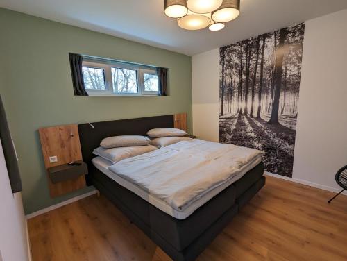 Schlafzimmer mit einem Bett mit Wandgemälde in der Unterkunft apartments-like-home-199 Mahlow in Mahlow