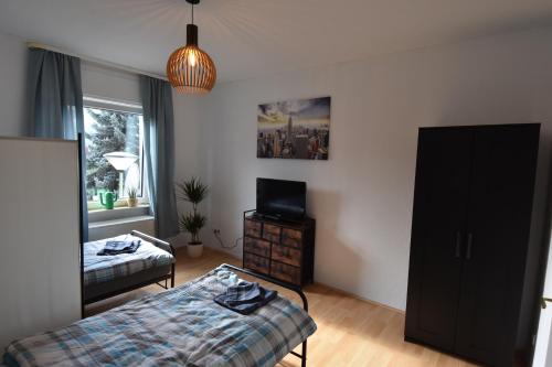 um quarto com uma cama e uma televisão em Ferienwohnung Hohenlimburg em Hagen