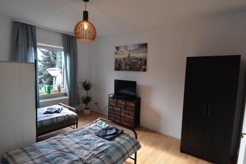 a bedroom with a bed and a tv in it at Ferienwohnung Hohenlimburg in Hagen