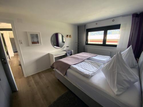sypialnia z dużym łóżkiem i lustrem w obiekcie JOY w mieście Annenheim