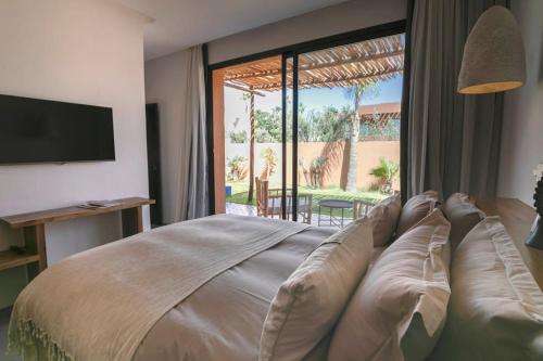 een slaapkamer met een groot bed en een groot raam bij Villa 4 chambres - Piscine in Marrakesh