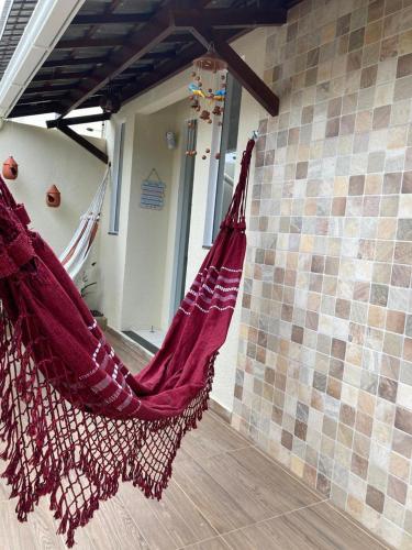 a hammock hanging from a wall in a room at Casa Brisas Arembepe - arejada e aconchegante - litoral norte da Bahia - WiFi in Arembepe