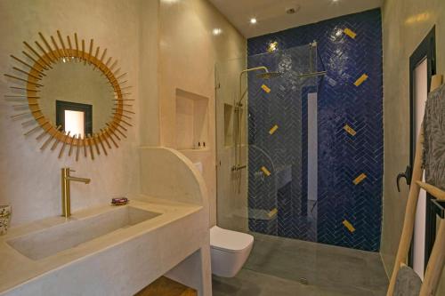 een badkamer met een wastafel en een douche met een spiegel bij Villa 4 chambres - Piscine in Marrakesh