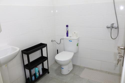 Baño blanco con aseo y lavamanos en Apartment Hay Arrid Nador قرب فران دبي en Nador