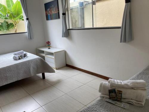 a white room with a bed and a window at Casa Brisas Arembepe - arejada e aconchegante - litoral norte da Bahia - WiFi in Arembepe