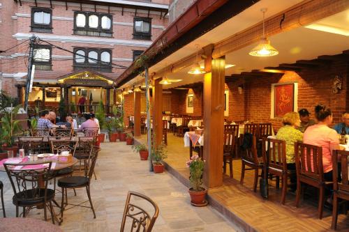 a restaurant with tables and people sitting at tables at Apsara Boutique Hotel in Kathmandu