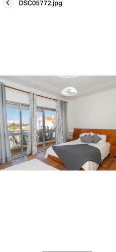 1 dormitorio con cama y ventana grande en Faustina's suite en Portimão