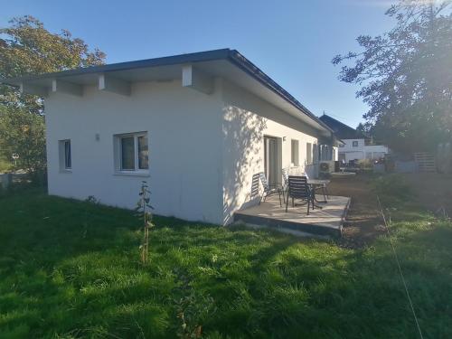 a white house with a table and chairs on a porch at Private Zimmer Wohnung Braunau 