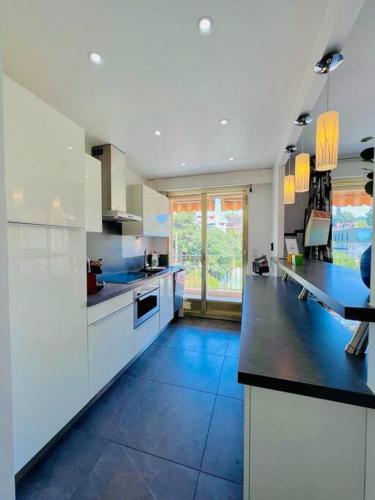 Il comprend une grande cuisine avec des placards blancs et du carrelage bleu. dans l'établissement Le Pinède - Apt 4 Prs- Clim - 500m plages, à Antibes