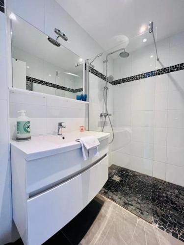 une salle de bain blanche avec un lavabo et une douche dans l'établissement Le Pinède - Apt 4 Prs- Clim - 500m plages, à Antibes