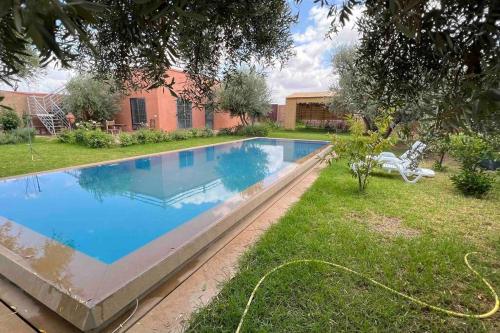 uma piscina no quintal de uma casa em Maison sur terrain privé de 1200m2 avec piscine4x12 em Marrakech