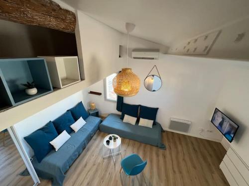 salon z niebieską kanapą i telewizorem w obiekcie L'Aixtra ! Cosy en centre ville historique d'Aix w Aix-en-Provence