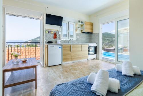 a kitchen with a table and a large window at Aloupi Pool Apartment in Skopelos Town