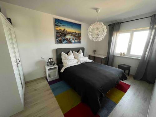a bedroom with a black bed with a colorful rug at Work & Stay Erlensee mit Stellplatz in Erlensee