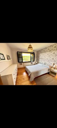 a bedroom with a large bed and a window at El Acebu in Colombres