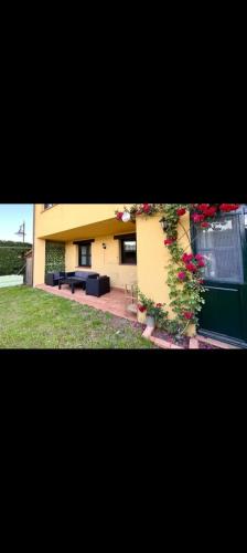 a building with a couch and flowers in a yard at El Acebu in Colombres