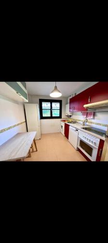 a kitchen with a table and a bench in a room at El Acebu in Colombres