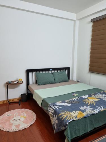 a bedroom with two beds and a rug at May's Cottage in Hanoi