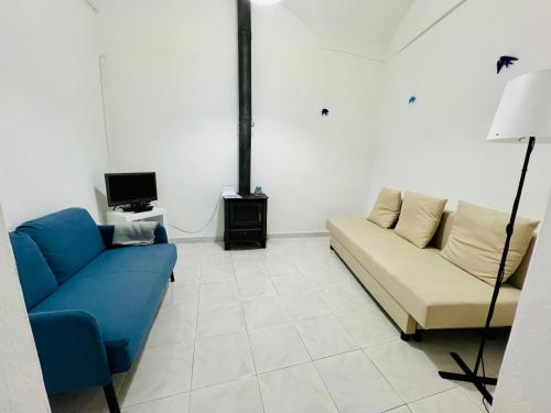 a living room with a couch and a tv at Casa da Salúquia in Moura