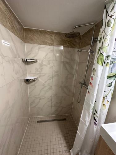 La salle de bains est pourvue d'une douche avec rideau de douche. dans l'établissement Gemütliche Gäste Suite für ruhige Nächte. Zentral, à Ichenhausen